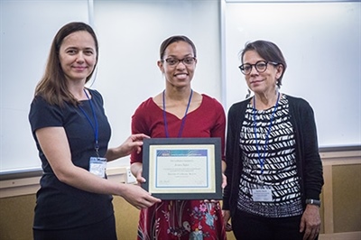 Professor Noemi Petra, left, and Professor Daniella Calvetti, right, present SIAM President Jessica Taylor, center, with a certificate of recognition.