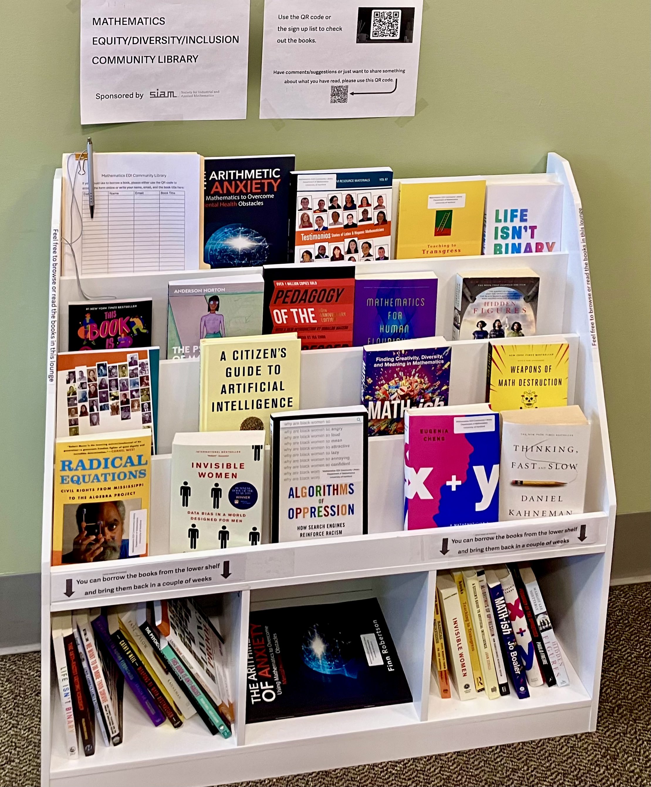 The Mathematics EDI Community Library within the Department of Mathematics at the University of Hartford contains roughly 20 books that explore themes of equity, inclusion, ethics, and the social dimensions of mathematics. Photo courtesy of Anastasiia Minenkova.