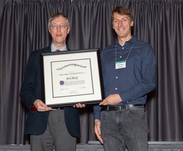 Peter Gangl receives the Richard C. DiPrima Prize from SIAM President Nick Higham at the 2018 SIAM Annual Meeting.