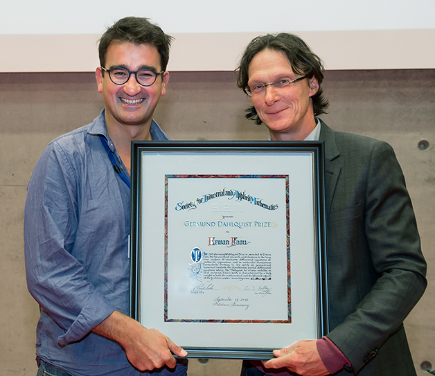 Sebastian Reich (right) presents Erwan Faou (left) with the 2015 Germund Dahlquist Prize. Photo © K. Fritze.