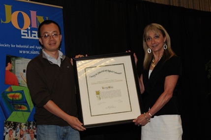 Irene Fonseca (right), then-president of SIAM, presents the 2013 Wilkinson Prize to Lexing Ying.