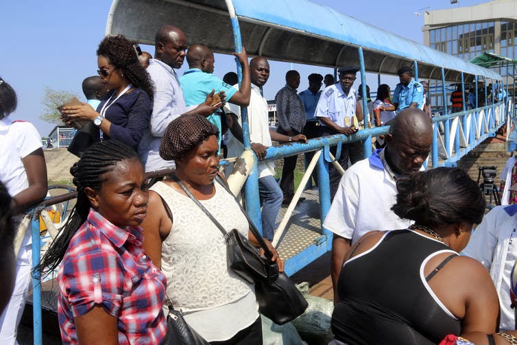 Passengers wait to have their temperature taken by healthcare workers at Ngobila Beach in Kinshasa, Democratic Republic of the Congo, May 24, 2018. AP Photo/John Bompengo.
