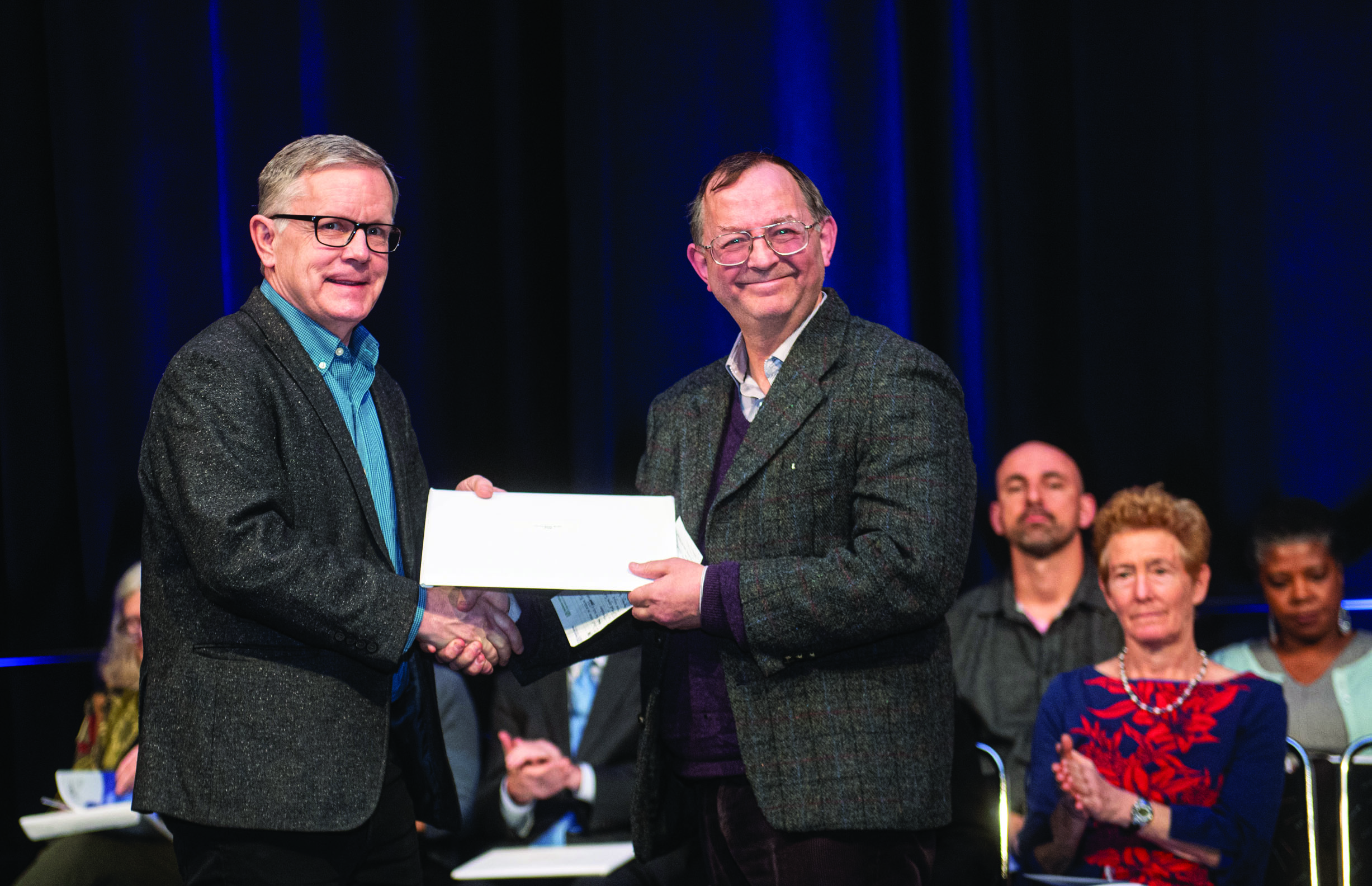 Chris Budd (right) accepts the 2020 Joint Policy Board for Mathematics (JPBM) Communications Award from Mathematical Association of America (MAA) President Michael Dorff. Photo courtesy of Kate Awtrey, Atlanta Convention Photography.