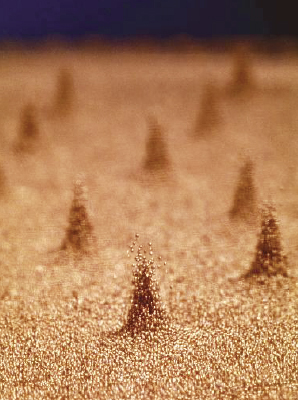 <strong>Figure 1.</strong> Pillars of vibrating copper beads are much higher than the surrounding material and appear to stand independently of each other. Image courtesy of [4].
