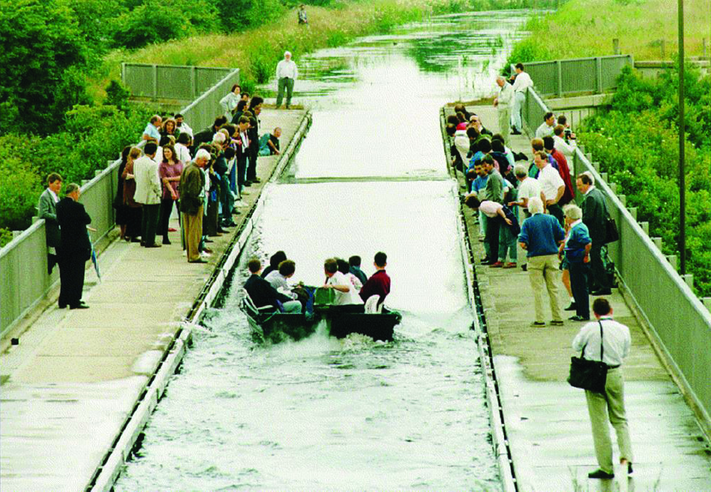 <strong>Figure 1.</strong> On July 12, 1995, an international gathering of scientists witnessed a re-creation of John Scott Russell’s famous “first” sighting of a solitary wave on the Union Canal near Edinburgh, Scotland. Photo reproduced with permission from the Department of Mathematics at Heriot-Watt University in Edinburgh.