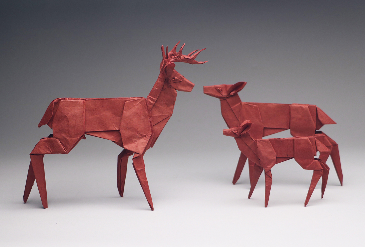 <em>Whitetail Family BP</em> (2018). In this origami family of white-tailed deer, each figure is folded from a single uncut square. A deer with antlers was the inspiration for Robert Lang’s development of tree theory in origami design. Figure courtesy of the author.